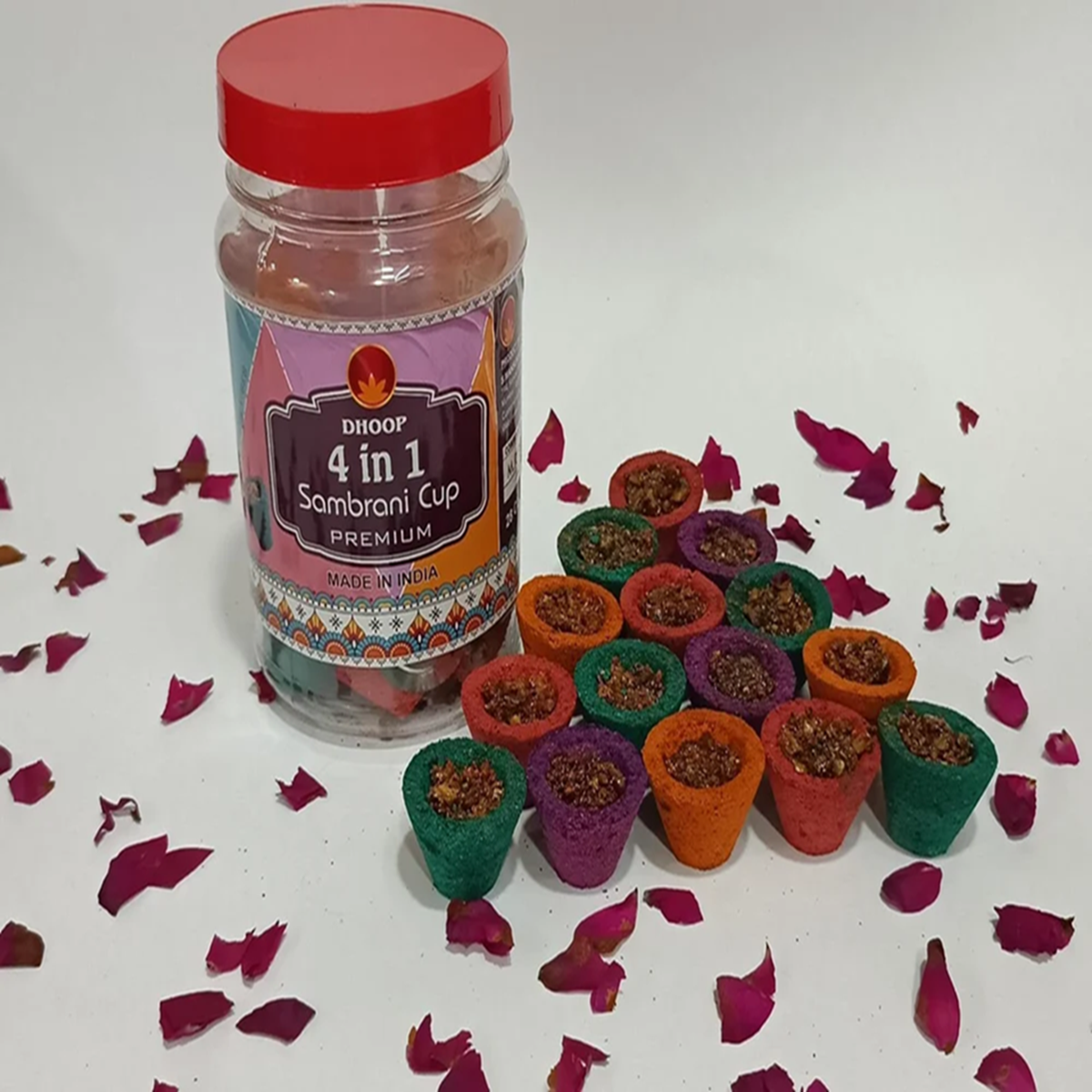 Jar of 4 in 1 Sambhrami Cup with colorful cups on a white background with red flower petals.